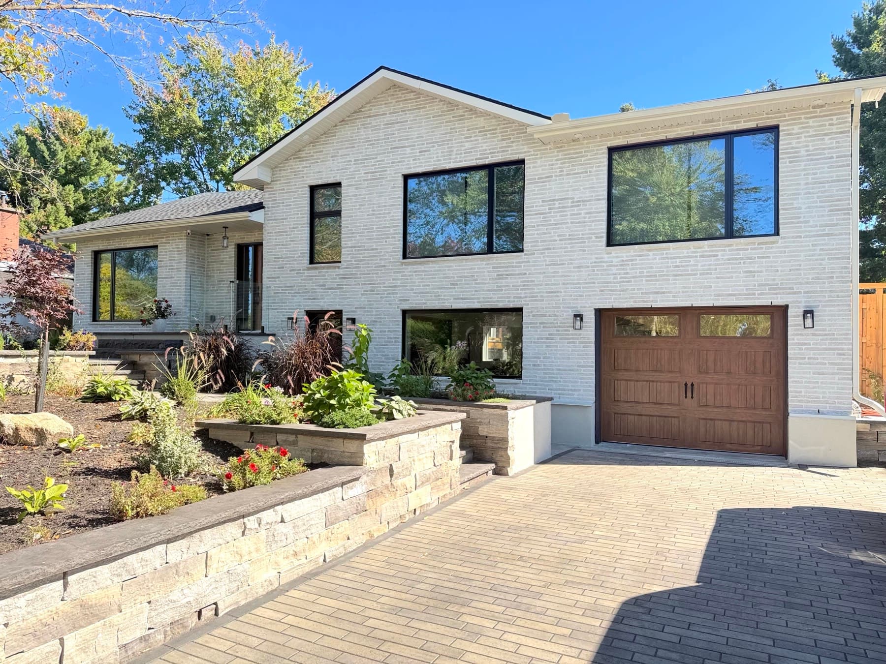 The finished split-level: light brick, large windows and new landscaping