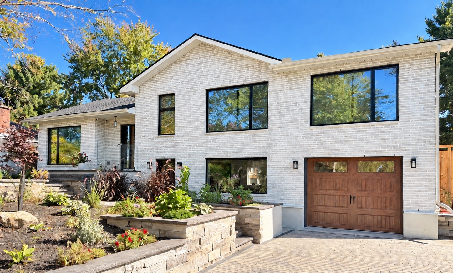 The finished split-level: light brick, large windows and new landscaping